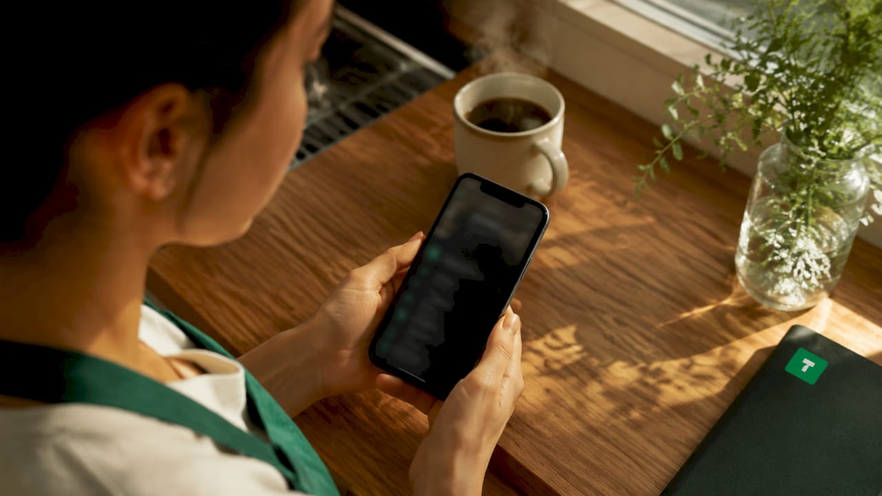 Barista using digital tipping app on smartphone