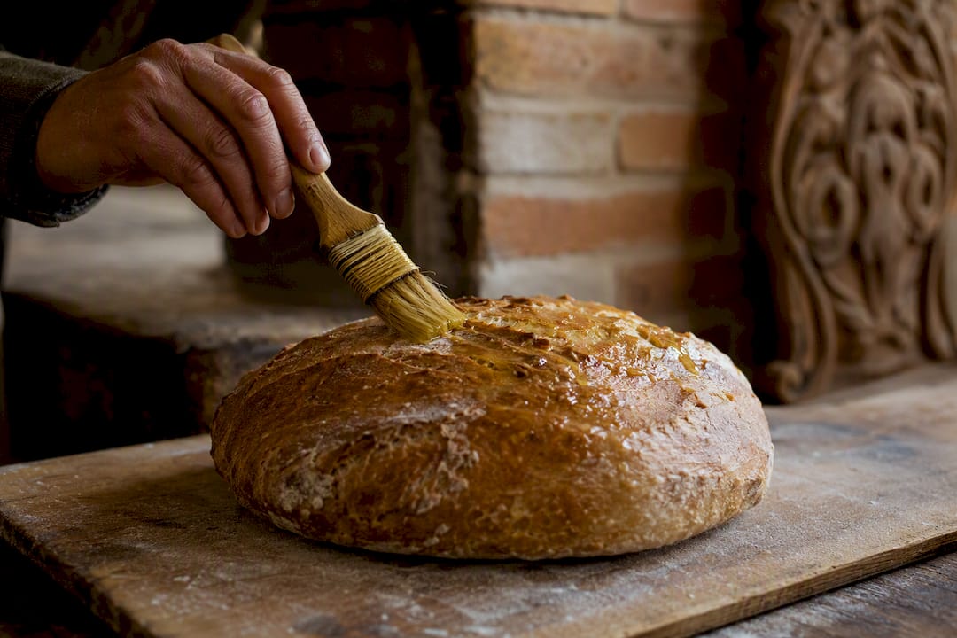 Olivenöl auf die Brotkruste streichen vor dem Backen
