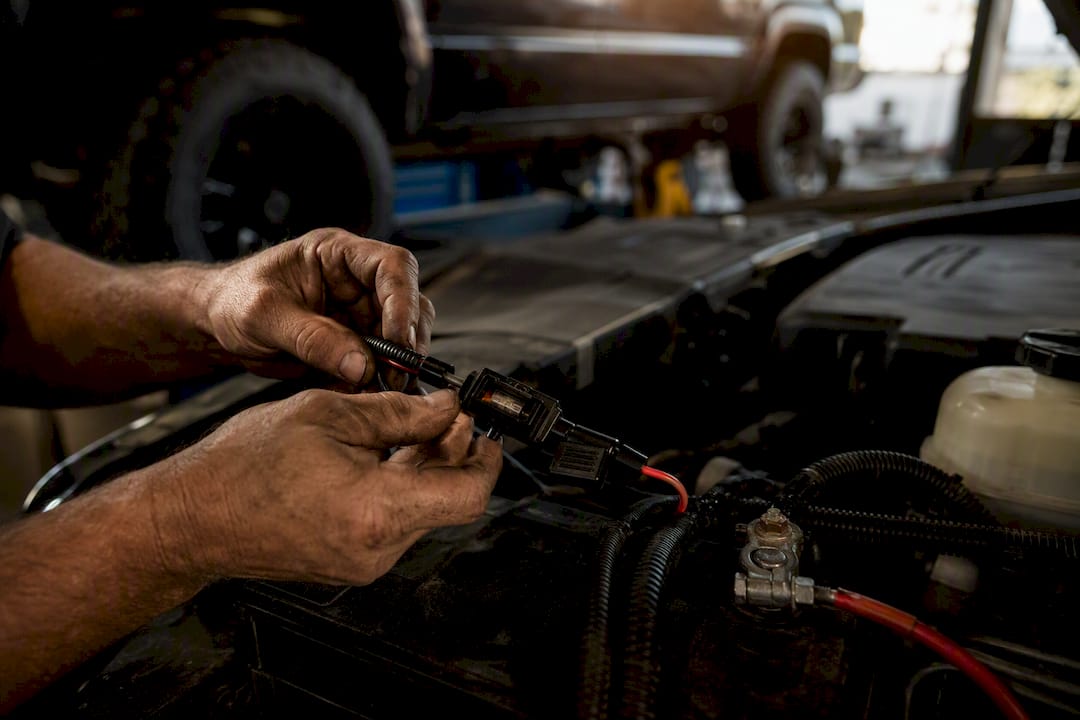 Hands wiring fused relay harness under truck hood