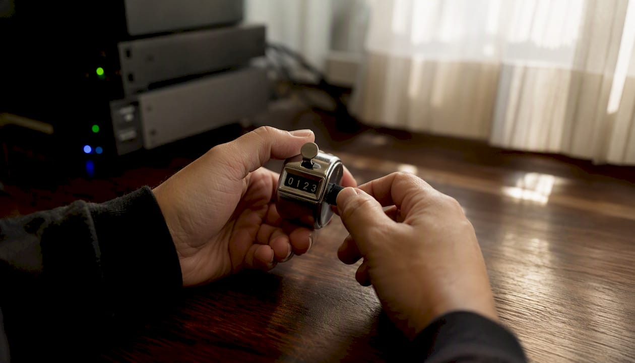 Hands adjusting a mechanical counter device