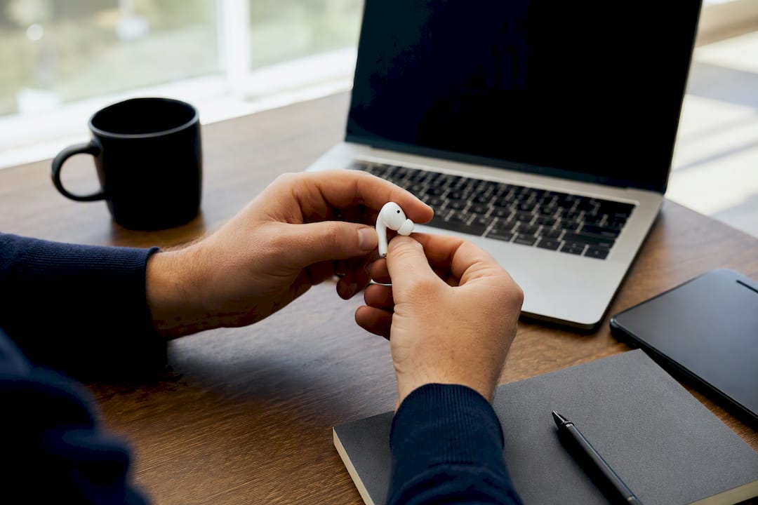 Hands inspecting communication device on desk