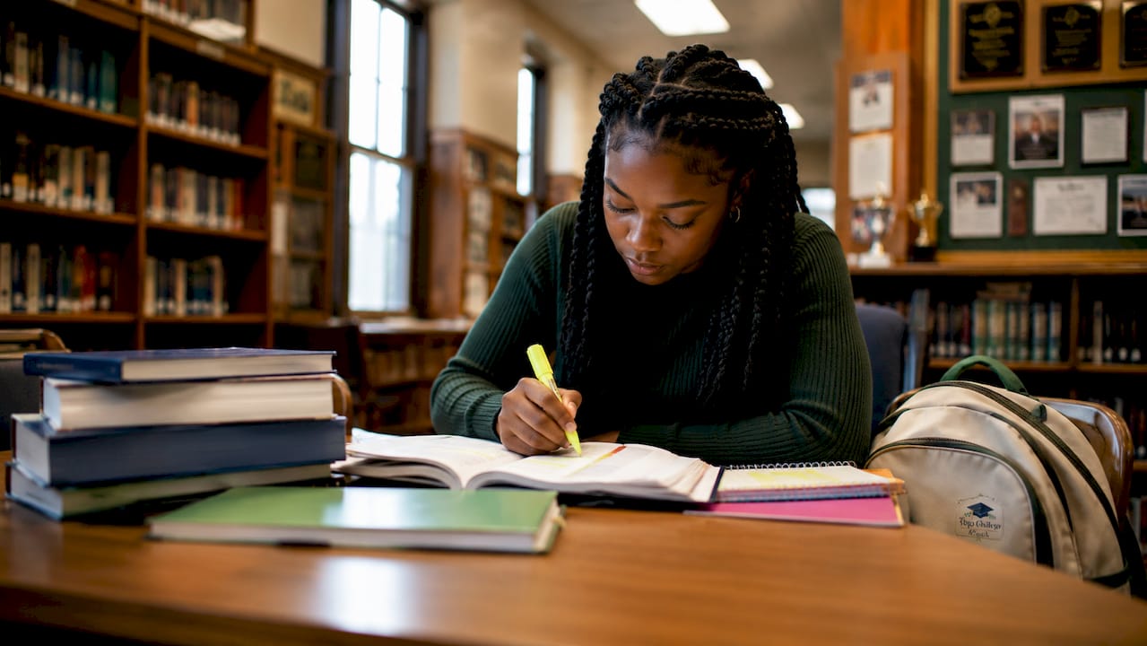 High school student highlighting textbook notes