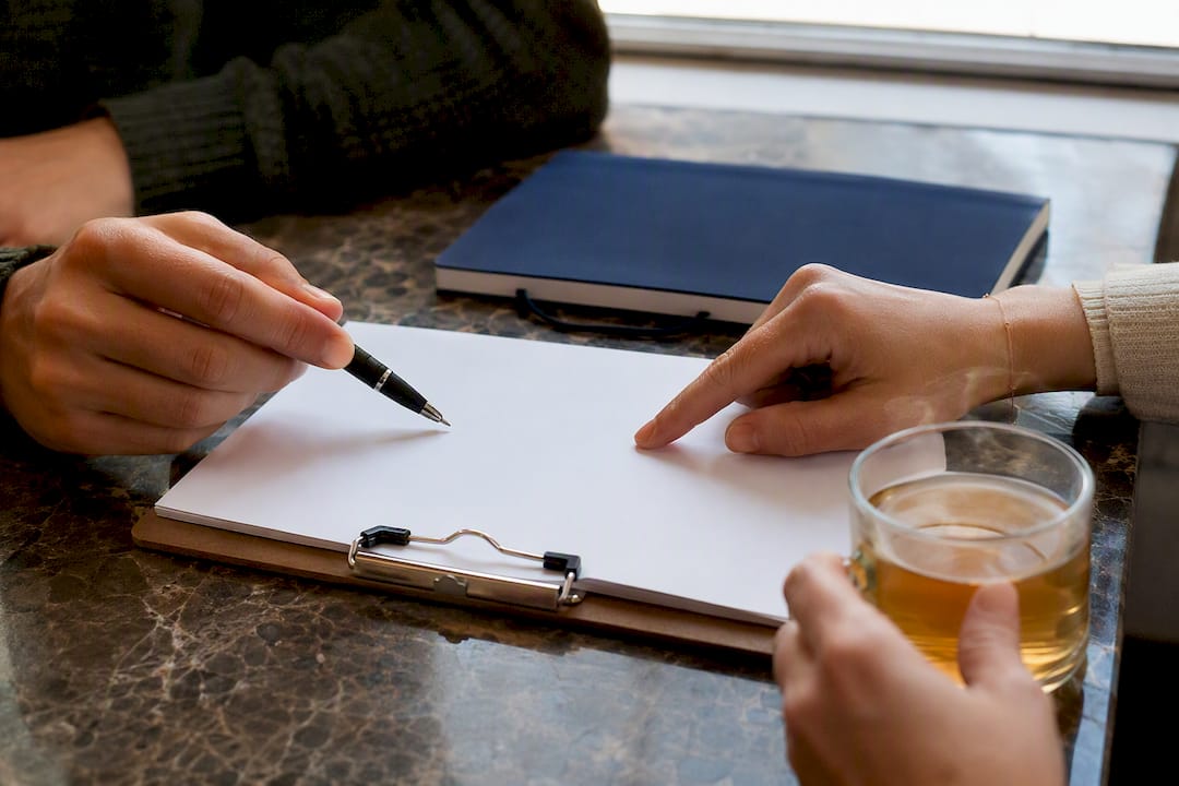 Hands marking a checklist on a table