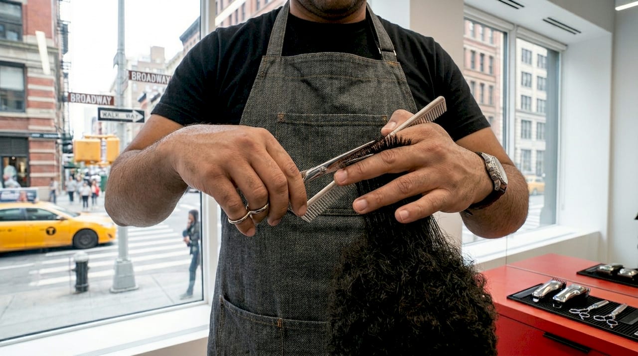 Barber demonstrating scissor-over-comb technique