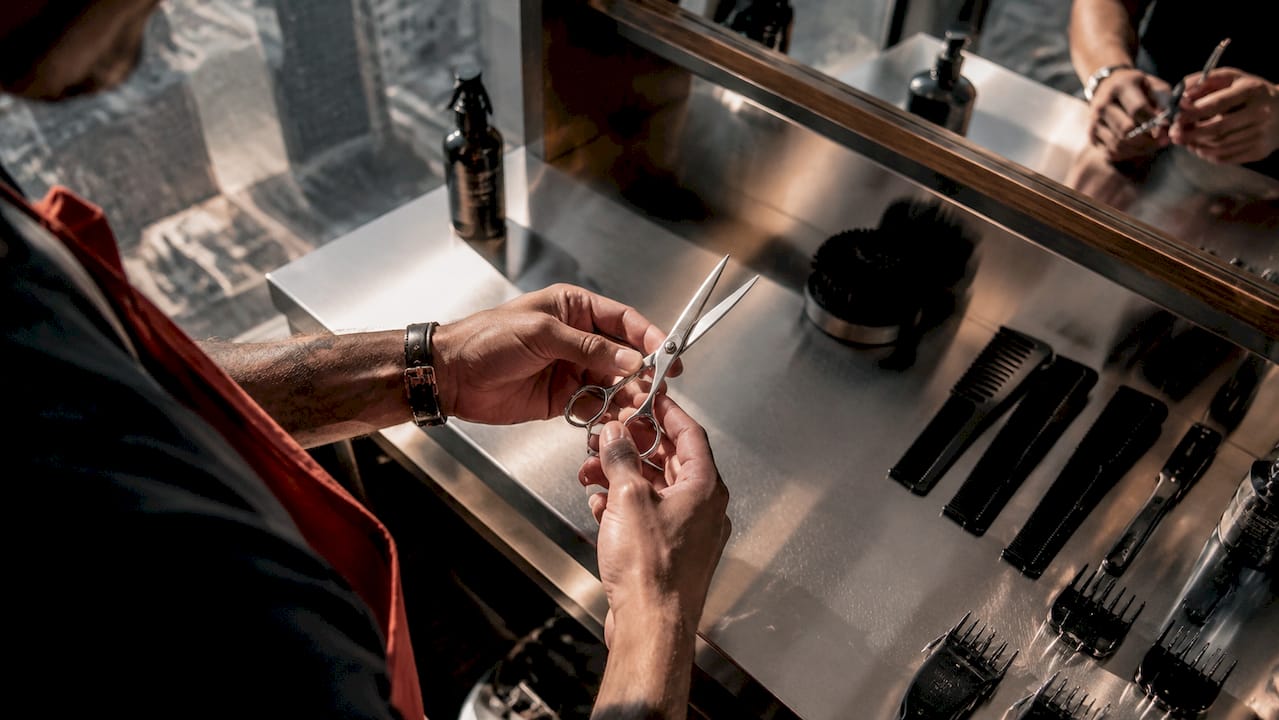 Hands holding custom barber scissors in independent shop
