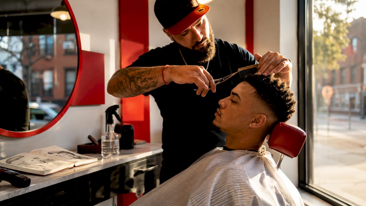Barber adjusting haircut and taking notes