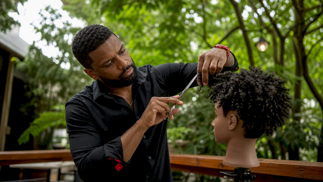 Barber practicing dry cutting on mannequin