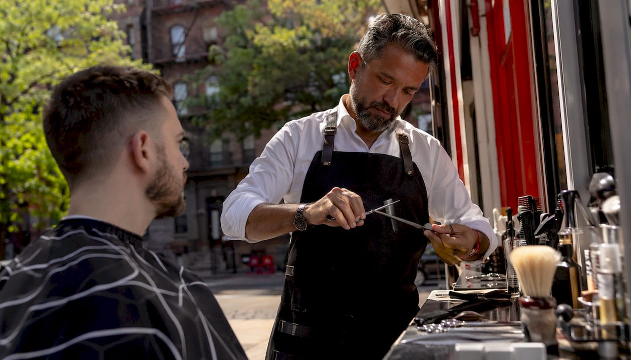 Barber sanitizing tools before haircut in shop