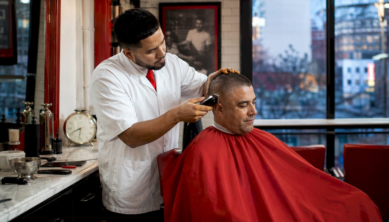 Barber shaping buzz cut with clippers