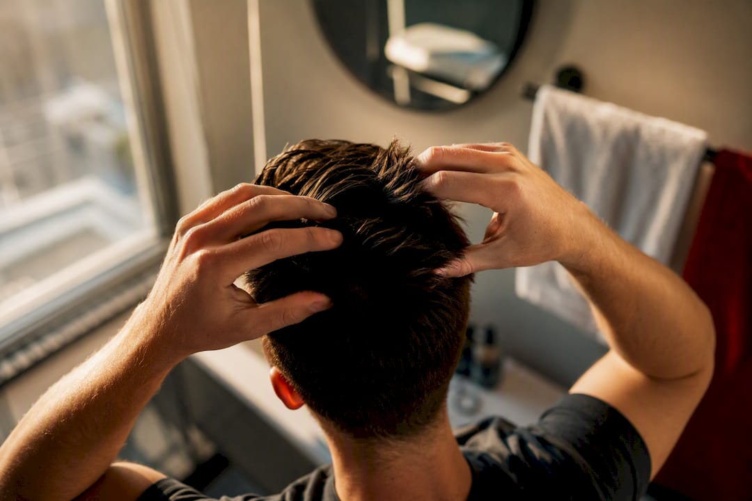 Hands applying hair paste to Ivy League haircut