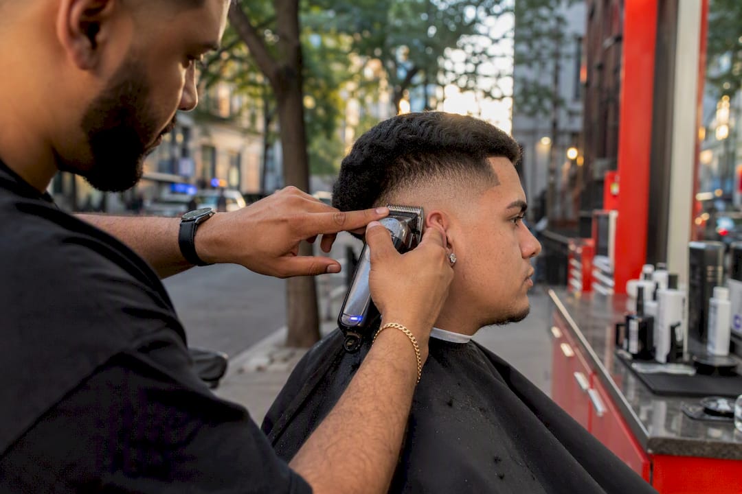 Barber shaping burst fade haircut behind ear
