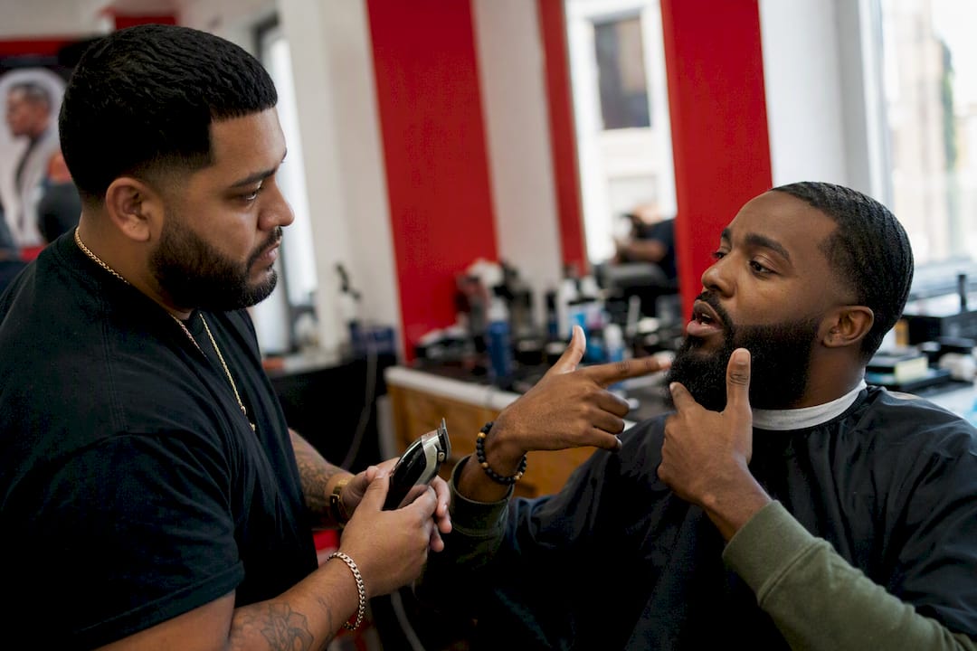 Customer hand giving beard fade instructions