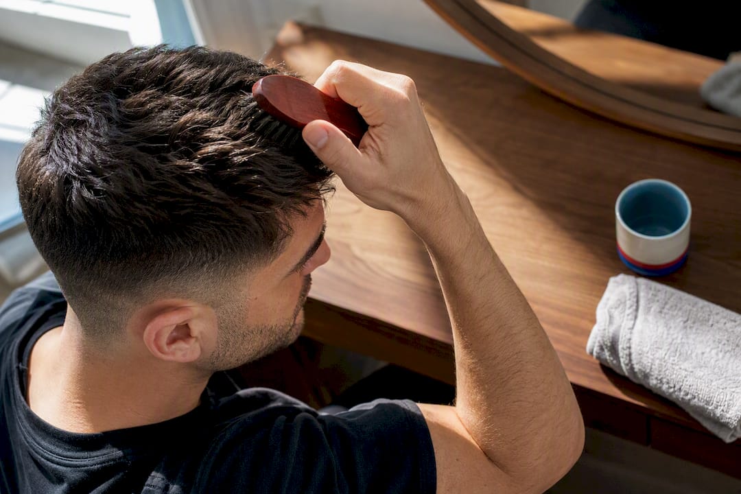 Man brushing textured hair at home