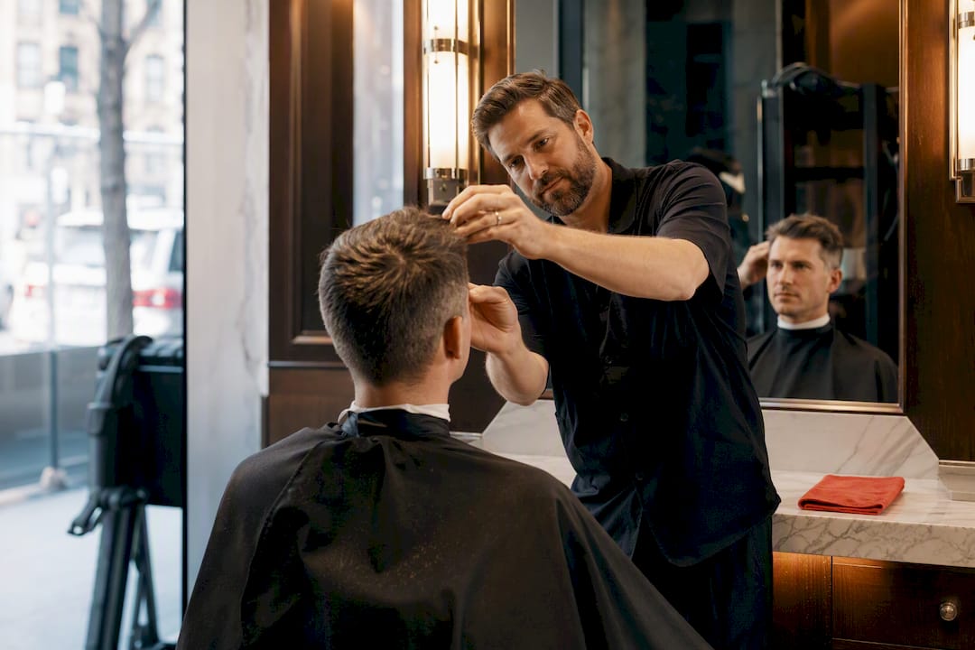 Barber assessing a grown-out haircut in mirror