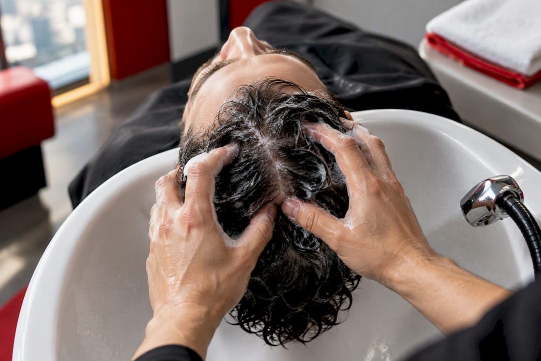 Hands gently massaging scalp during washing