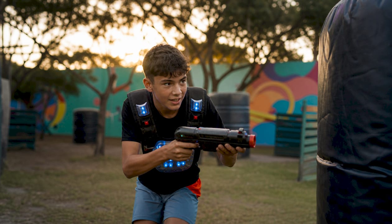Teen boy sprinting in outdoor laser tag game