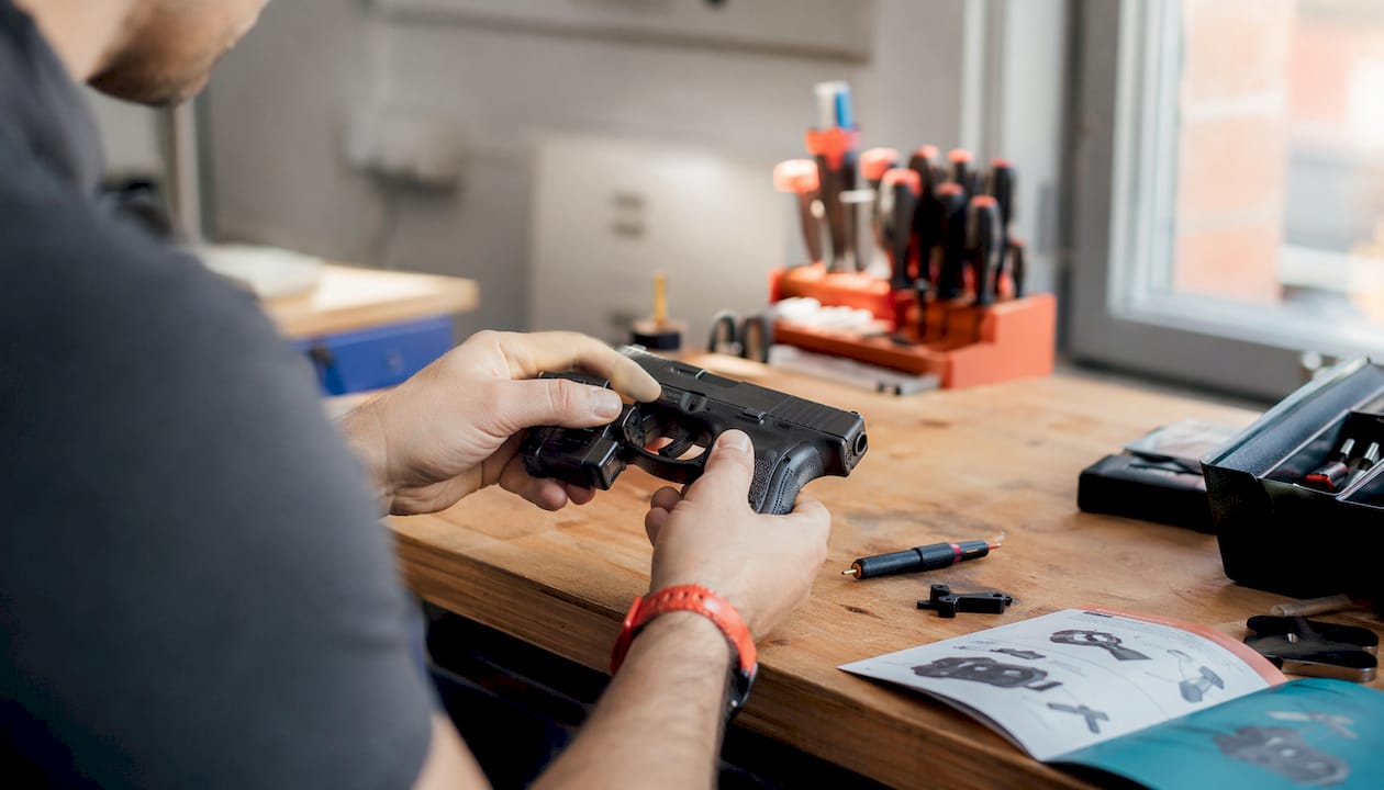 Hand attaching motion sensor to pistol rail