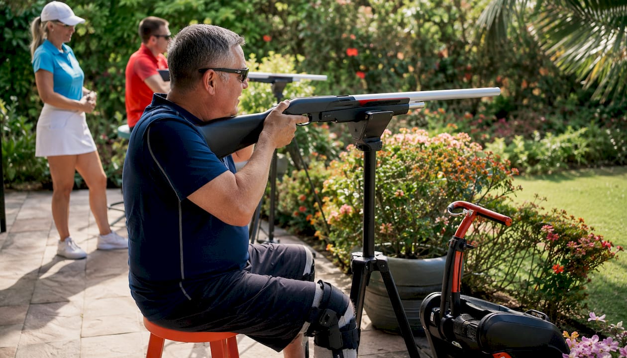 Man seated shooting in adapted laser clay setup
