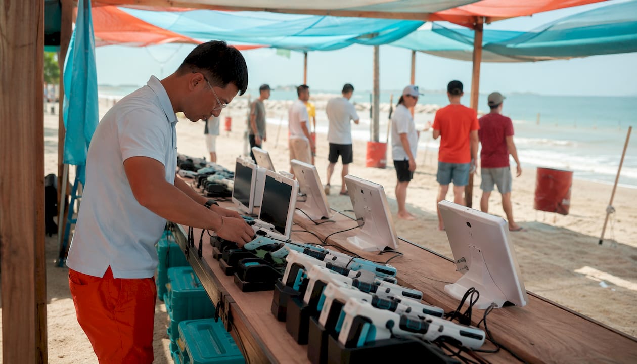 Technician setting up laser clay shooting equipment indoors