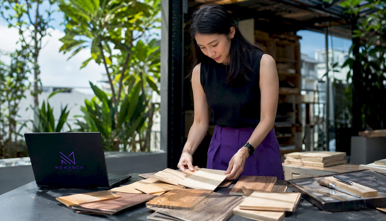 Hands arranging wood samples on workshop bench