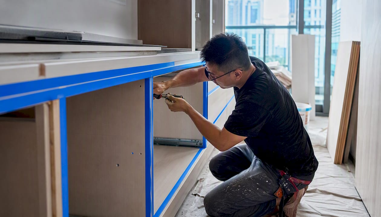 Carpenter assembling kitchen cabinetry hardware