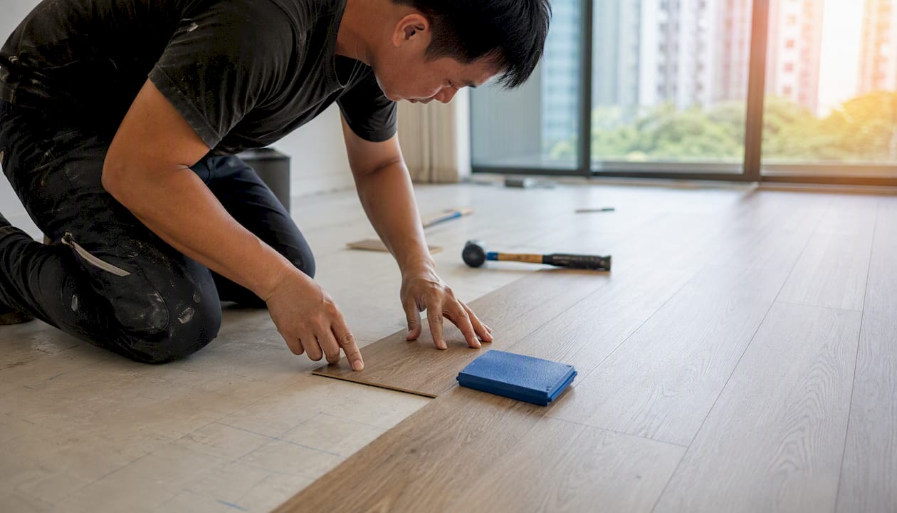 Hands installing vinyl flooring in Singapore home