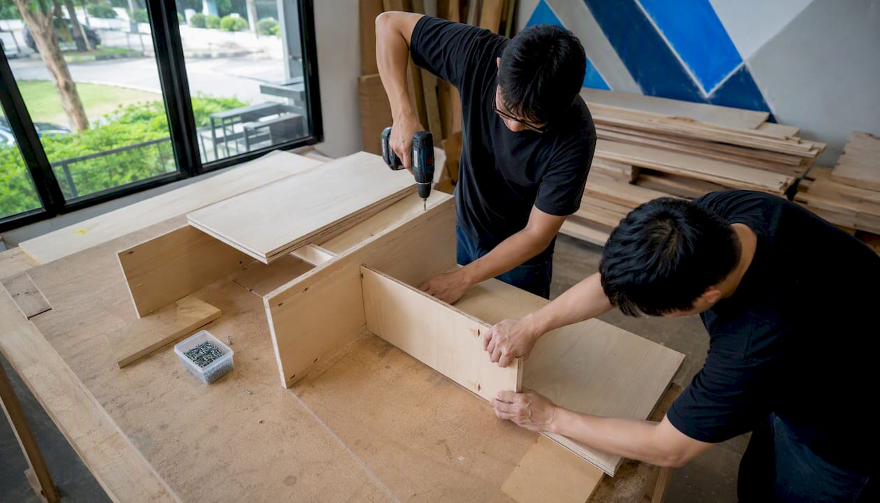 Carpenters assembling wood TV console