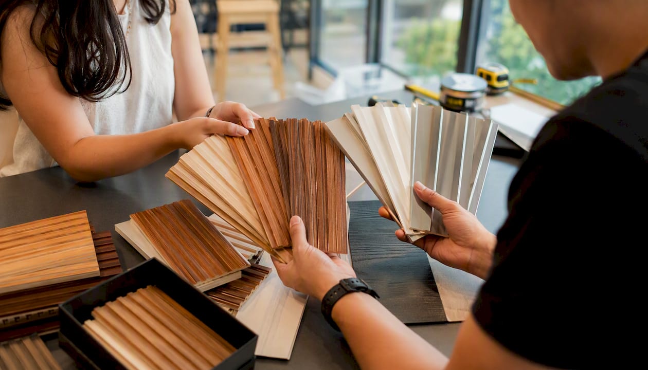 Hands comparing fluted wall material samples