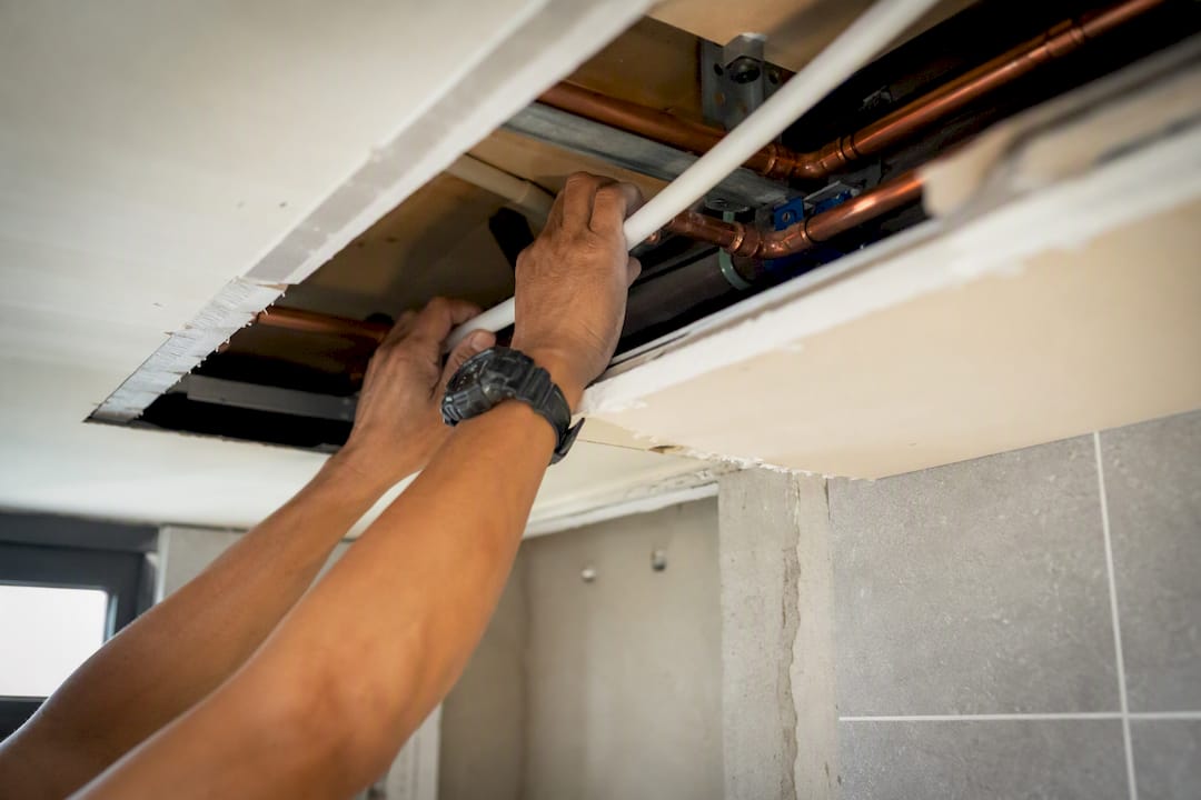 Hands plumbing ceiling for rain shower