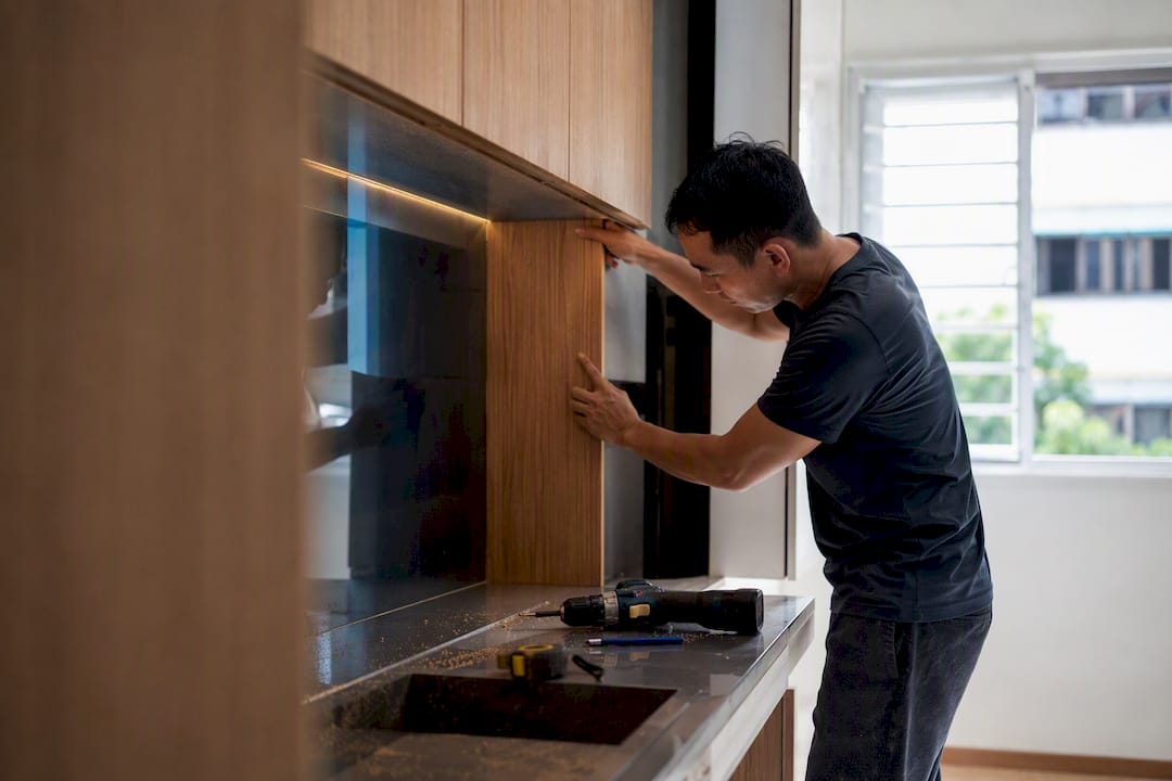 Asian carpenter fitting built-in wardrobe panels