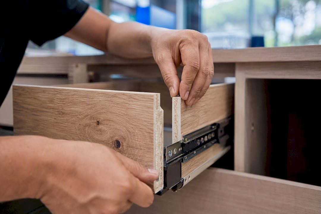 Carpenter hands installing kitchen cabinet