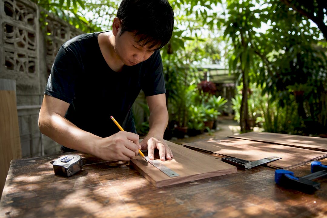 Carpenter measuring wood panel in studio