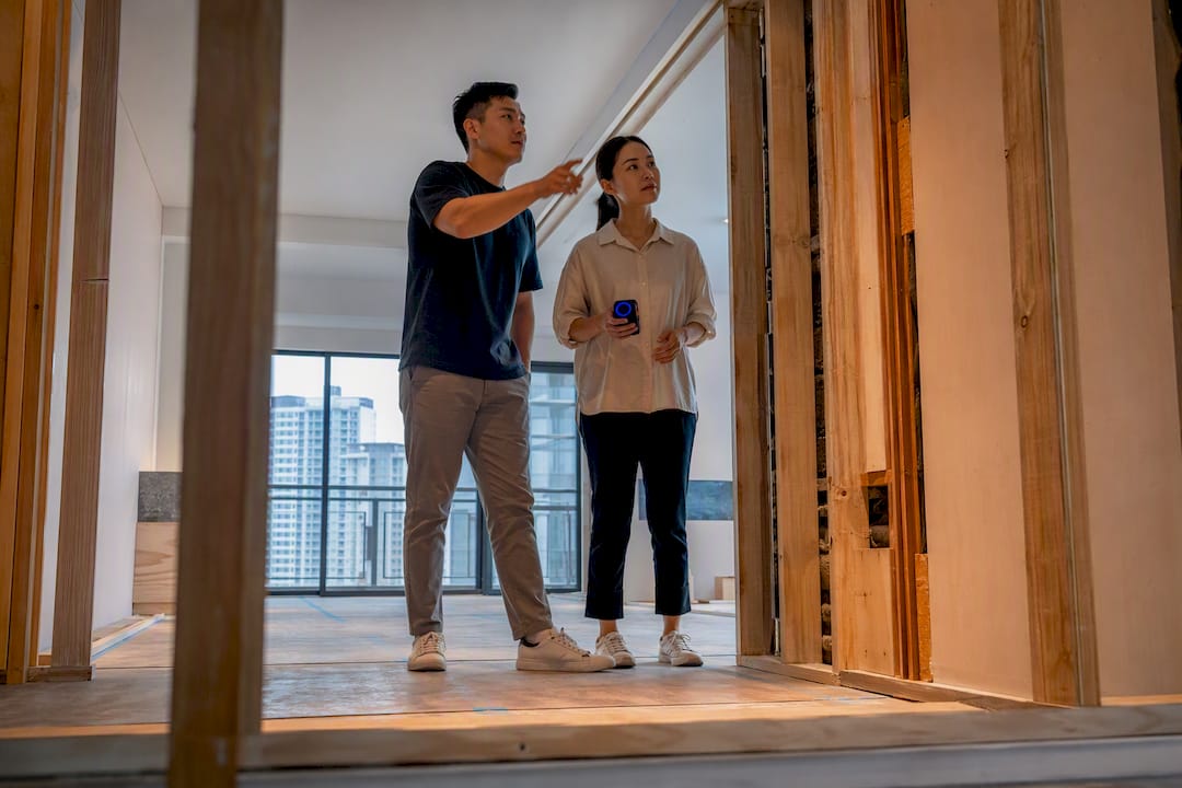 Asian homeowner reviewing renovation progress