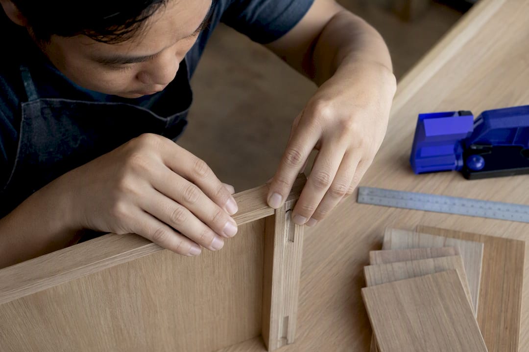 Carpenter inspecting custom cabinet joinery