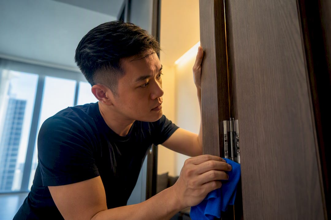 Asian homeowner checking bespoke joinery hinge