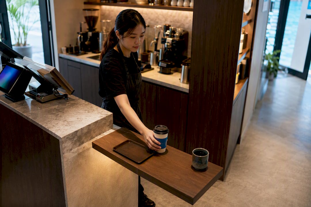 Barista placing drink on pickup shelf