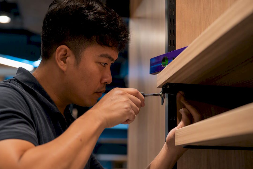 Carpenter checking retail shelf bracket alignment