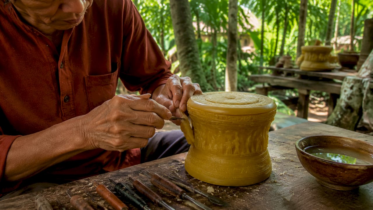 Hands crafting wax model for bronze casting