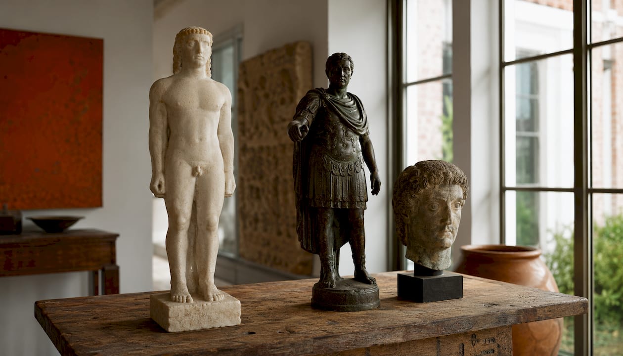 Three antique statues representing cultural roles