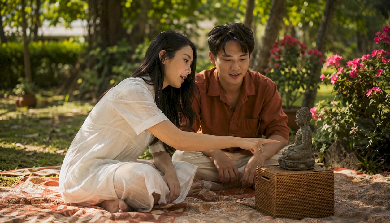Young couple exploring symbolic Buddha statue
