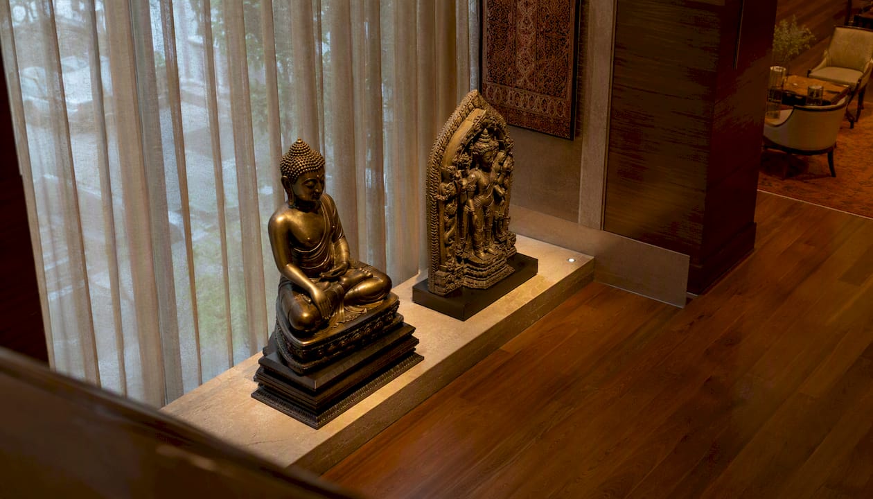 Bronze and stone Asian sculptures in hotel lobby corner