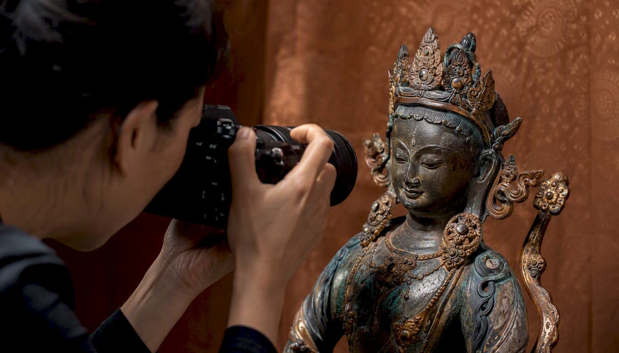 Close-up of photographing sculpture's distinguishing marks