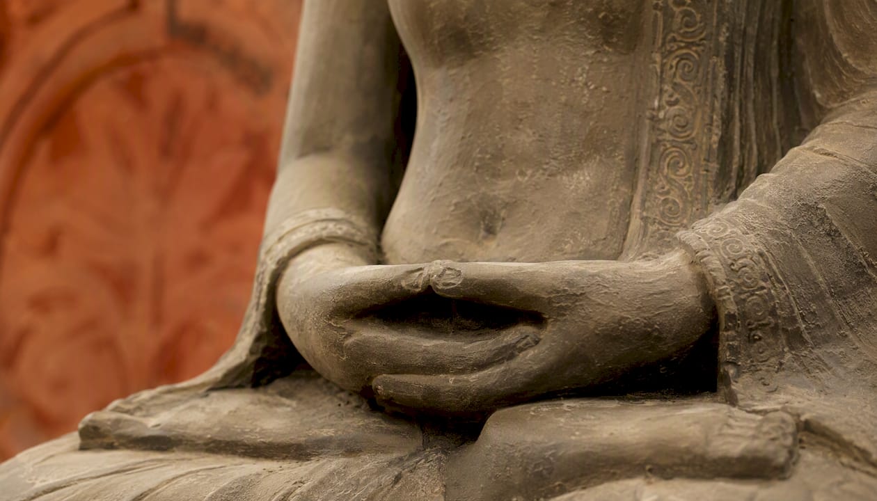 Close-up of Buddha statue's dhyana mudra hands