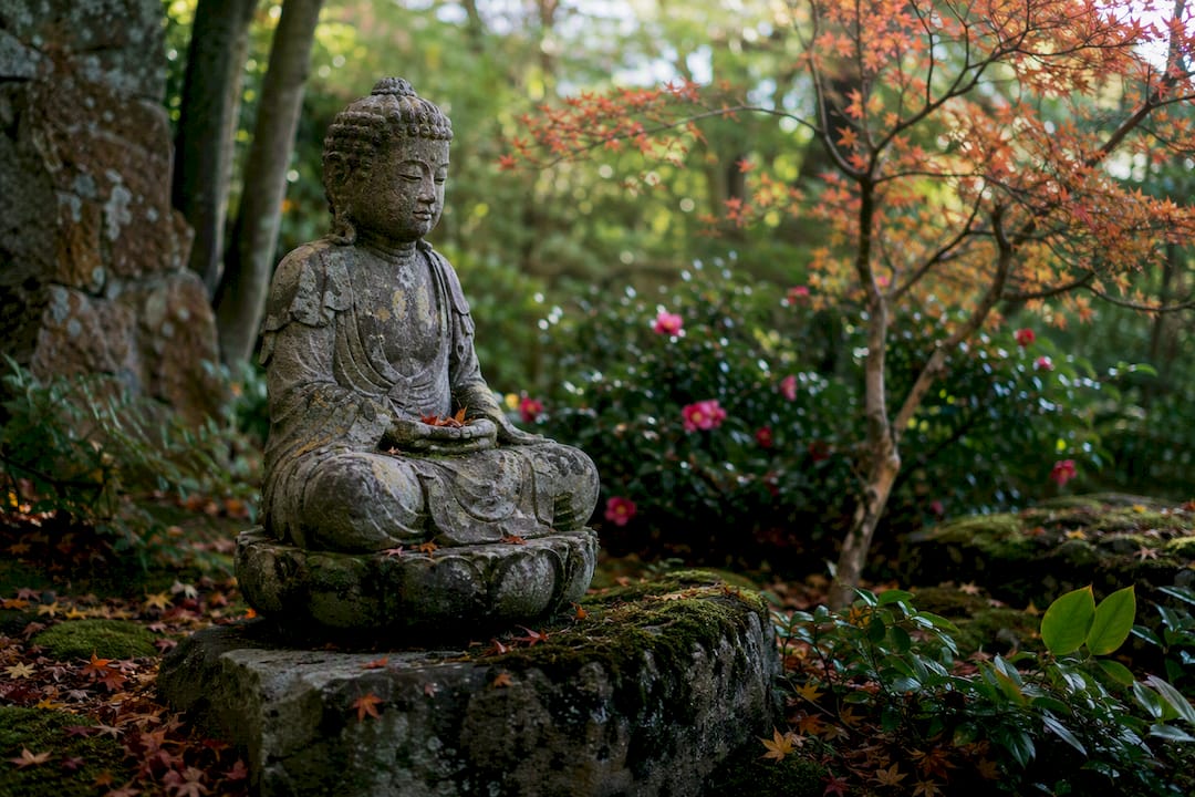 Stone Buddhist sculpture in garden setting