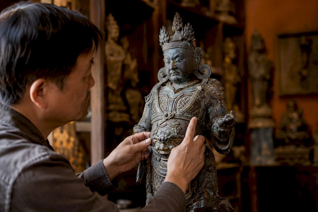 Hands inspecting bronze Buddhist statue detail