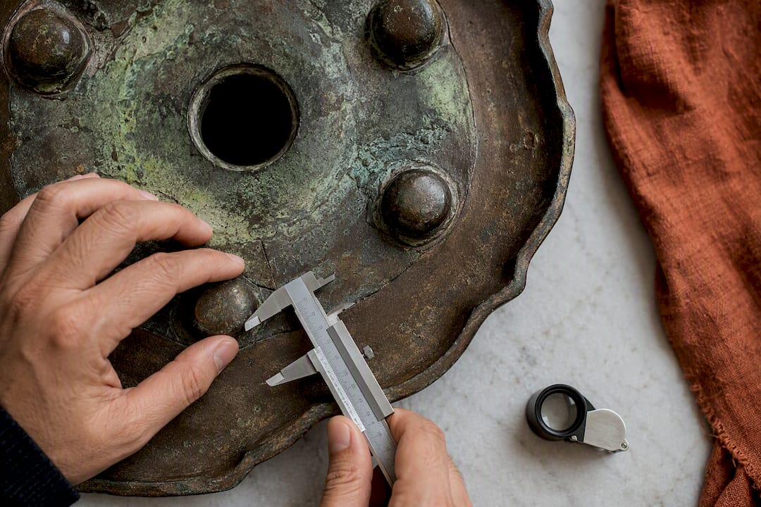 Specialist inspecting bronze base casting details