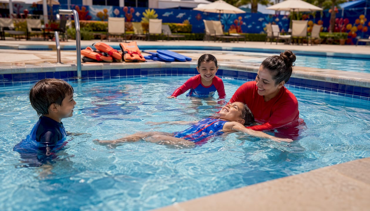 Children in beginner swim lesson at pool