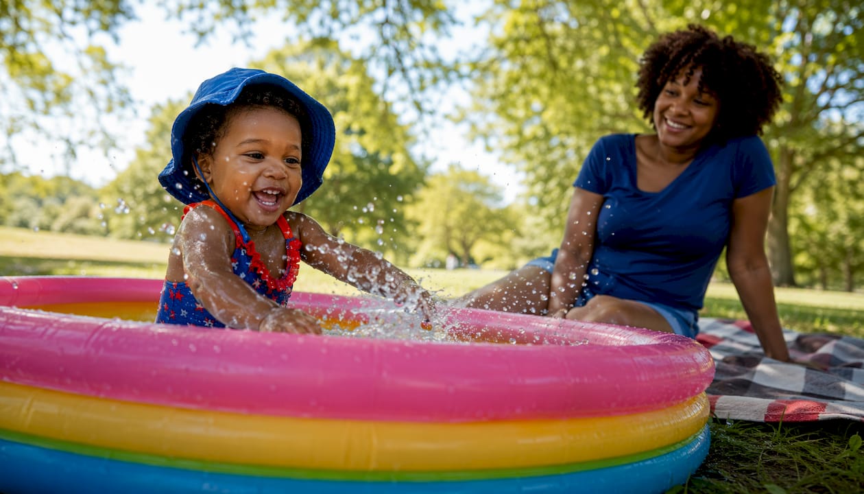 Toddler splashing water outdoors playfully