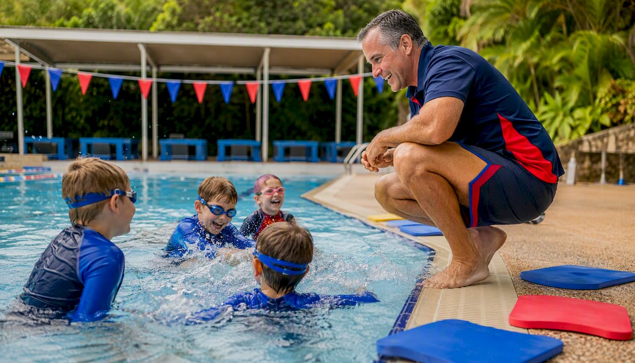 Swim instructor watching children float in pool
