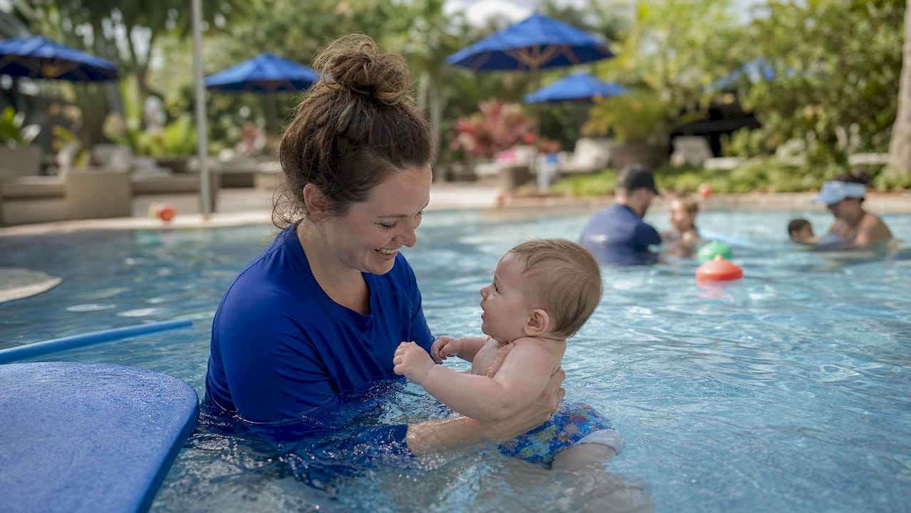 Mother holding baby in swimming pool